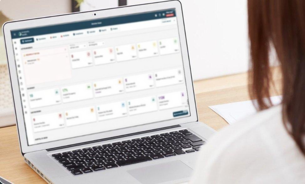 A care manager using the connects.health dashboard on a laptop, showing active incidents, occupancy and reviews due.